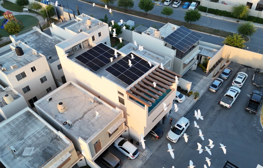 Vista aérea de una casa con paneles solares instalados en un fraccionamiento de Monterrey al atardecer