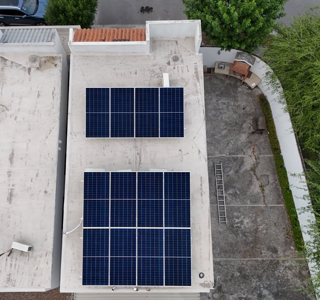 Vista desde dron de dos arreglos de paneles solares sobre losa plana