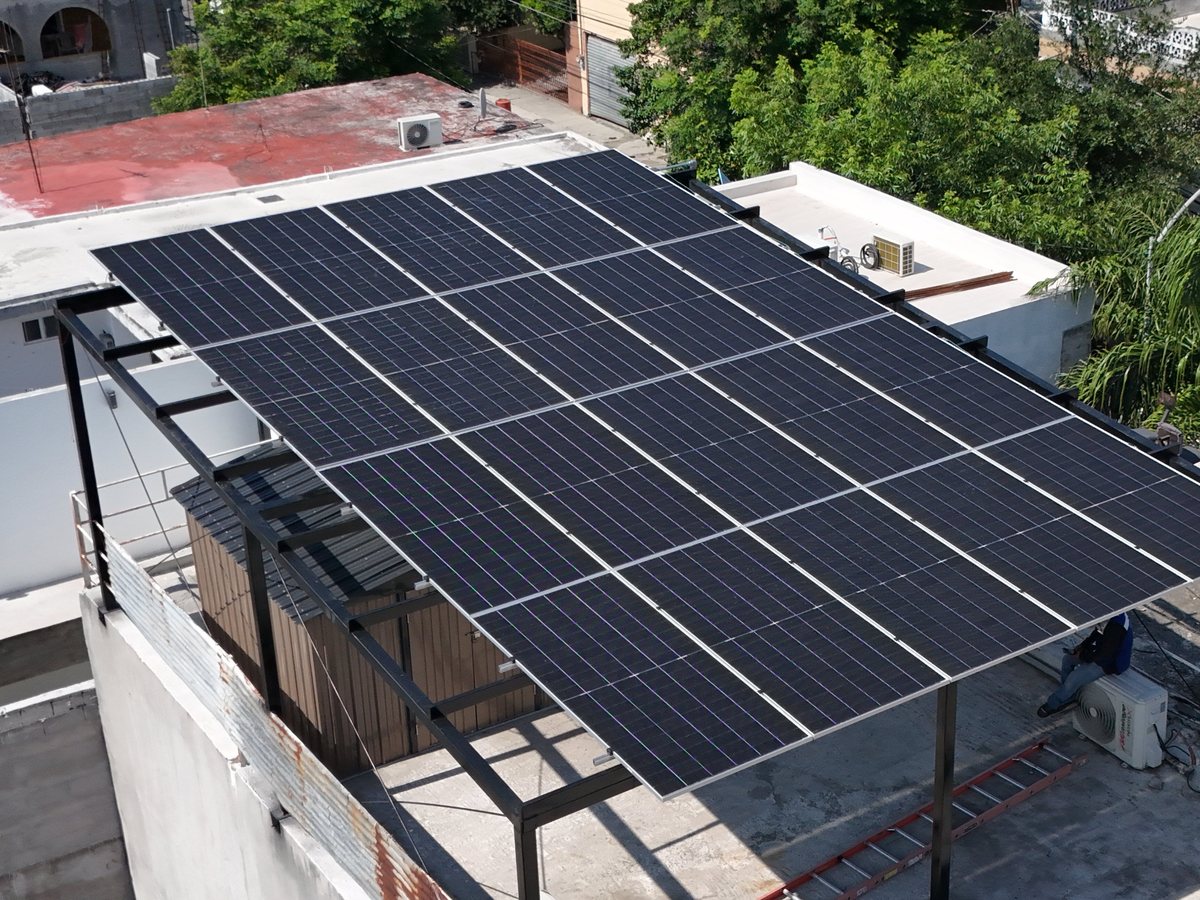 Vista desde dron de una pérgola solar con quince paneles sobre una azotea en Monterrey