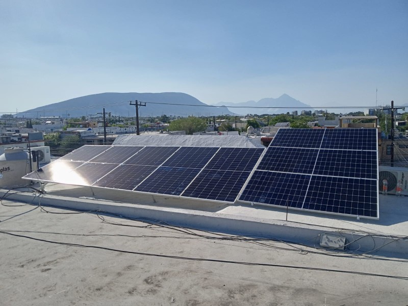 Dos arreglos de paneles solares sobre losa plana, con un cerro al fondo en un día soleado